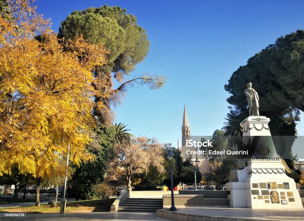 Godoy Cruz Square, in the departmental capital, in the background the San Vicente Ferrer church. City of Godoy Cruz, Mendoza, Argentina. Godoy Cruz Square with historic monument of Tomás Godoy Cruz in the departmental capital, at the background the San Vicente Ferrer church of neo-gothic architectural style. City of Godoy Cruz, Mendoza, Argentina. Mendoza Stock Photo