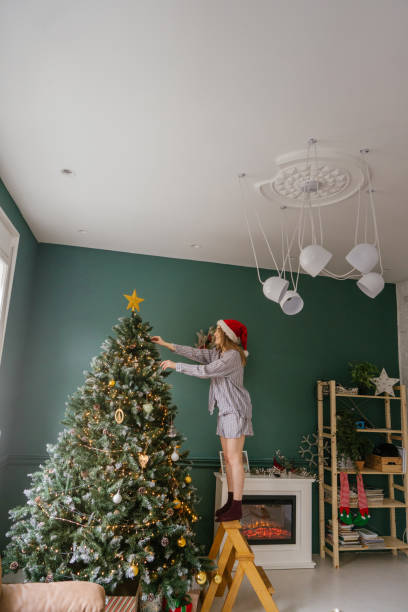 istock Young woman decorating her Christmas tree 1348207885
