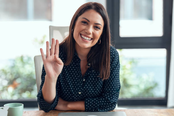 istock Smiling business woman looking and speaking through the webcam while making a video conference from the office. 1348209272