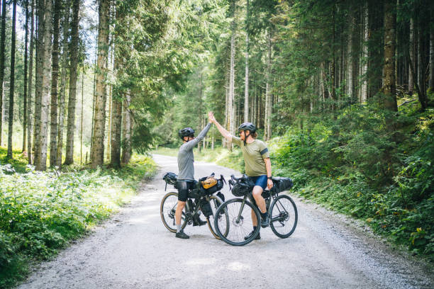 istock Male cyclists relax in sunny, lush forest in summer 1348210306