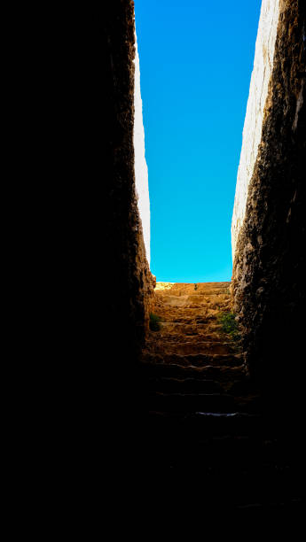 istock ancient stairs from the dark to the blue sky. 1348211202