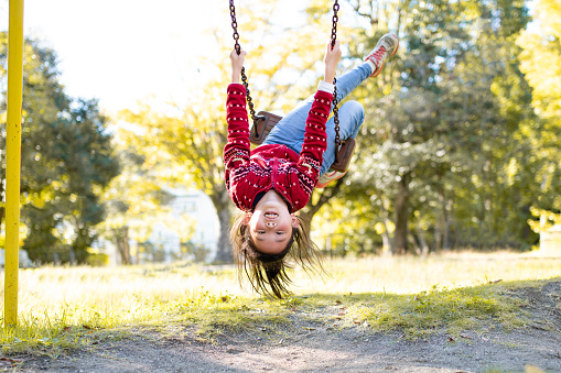 Girl playing on a swing in the autumn park