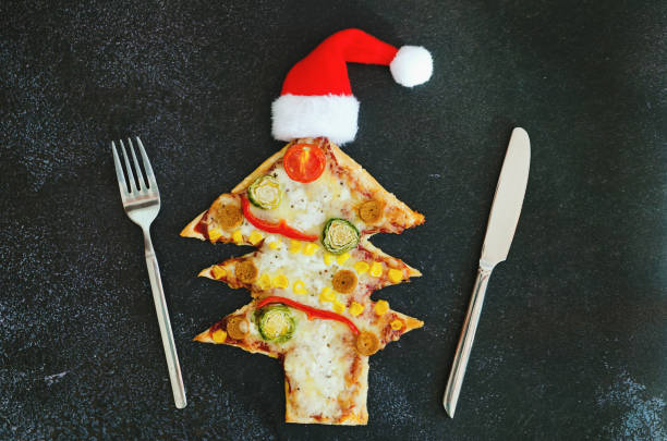 istock Delicious vegetarian Christmas tree pizza with tomatoes, cheese, vegetables on black background. Creative, funny food concept for kids. Top view, flat lay. Copy space. 1348214614