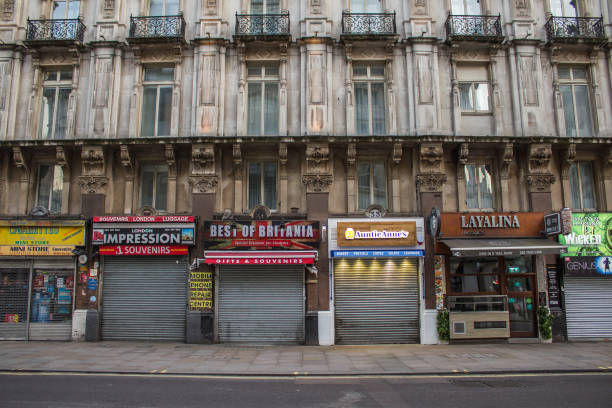 calle comercial vacía de londres, reino unido con frentes de tiendas de comestibles cerradas en medio de la escasez de suministros - london store fotografías e imágenes de stock