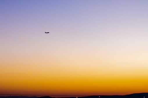 Silhouette airplane flying take off from runway on sunset