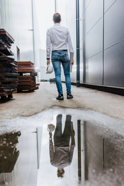 istock Rear view of engineer standing beside industrial building 1348217308