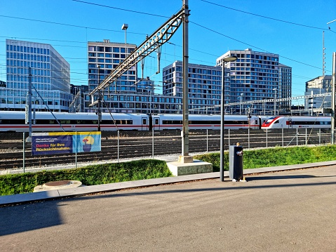 Europaalle is a new built district in Zurich next to the Main Railway Station. The Building have been constructed between 2009-2010. In Europaalee there are office Buildings, Appartments, Restaurants, Bars and a Shoppingmall. The Image shows the Europaalle during summer season with a train befor it.