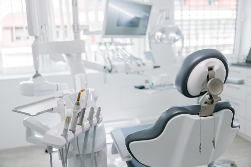 Taladros dentales modernos y silla vacía en el consultorio del dentista photo