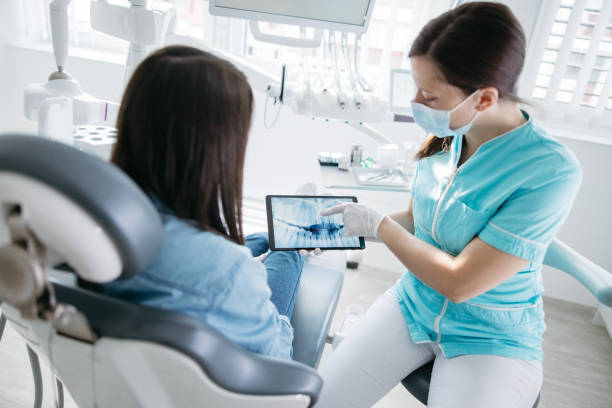 istock Dentist showing dental x-ray to patient 1348218545