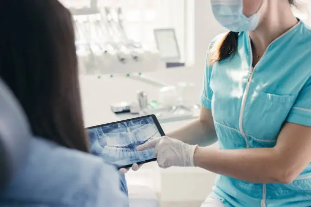 Close up of Dentist showing dental x-ray to patient at dentist's office