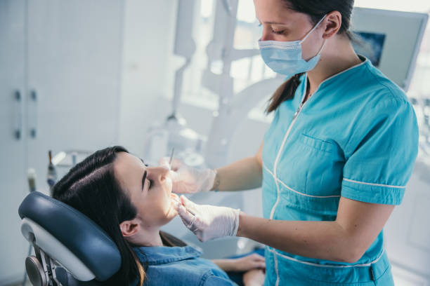 istock Dentist examining young female patient's teeth 1348218722