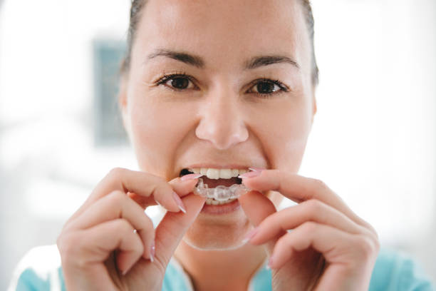 istock Dentist putting transparent teeth aligner in teeth 1348219006