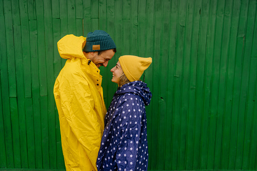 Photo of a romantic couple in love, having an romantic moment on the rain ; isolated on green background