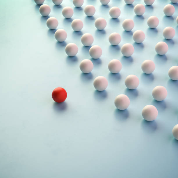 istock Leadership Concept: A group of white spheres with one sphere in red leading the group. 1348225522
