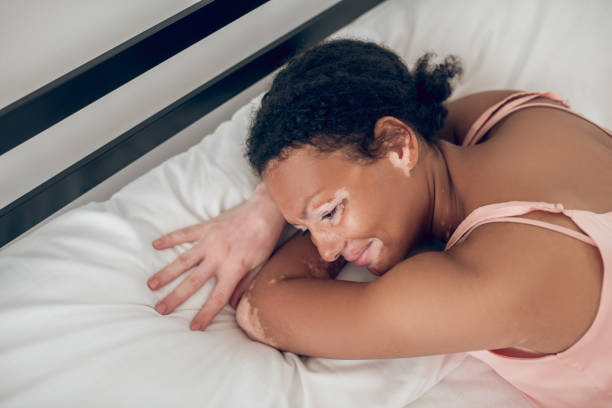istock A young woman lying in bed and looking relaxed 1348227008