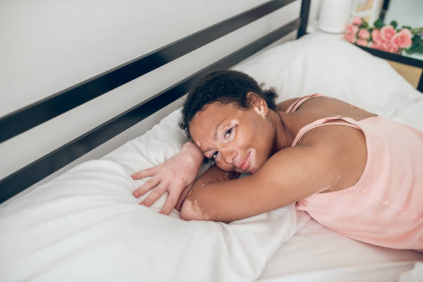 istock A young woman lying in bed and looking relaxed 1348227012