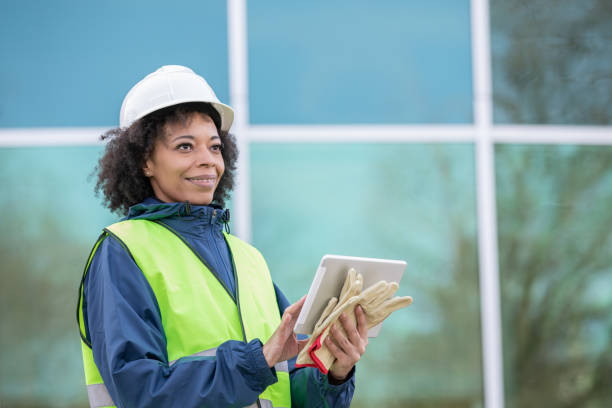 Woman is monitoring job site and using digital tablet stock photo