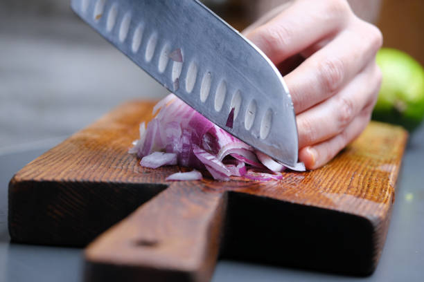Preparing homemade fresh salsa (pico de gallo) sauce. Chopping onion. Close-up