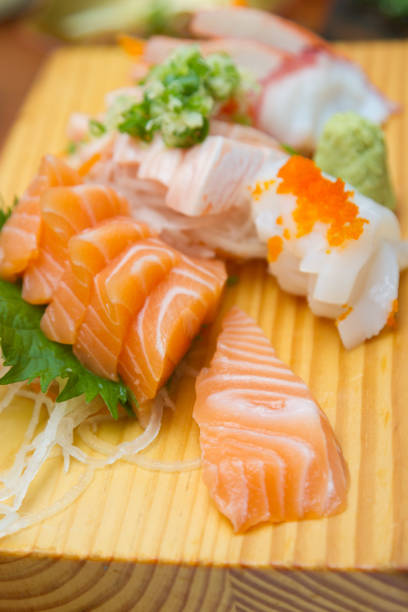 istock Sashimi (japanese food). Sliced raw seafood on wooden plate. 1348232320
