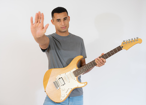 Handsome young man playing electric guitar isolated over white background.
