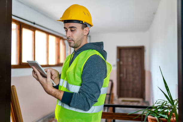 istock Private construction worker standing at customer's front door and checking quality with digital tablet 1348234966