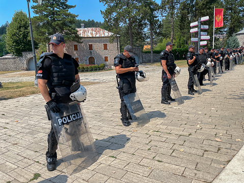 Cetinje, Montenegro, 8-22-2021: Policemen in gear form a line near the site of protests that ensued following an appointment of the new head of Serbian Orthodox Church.