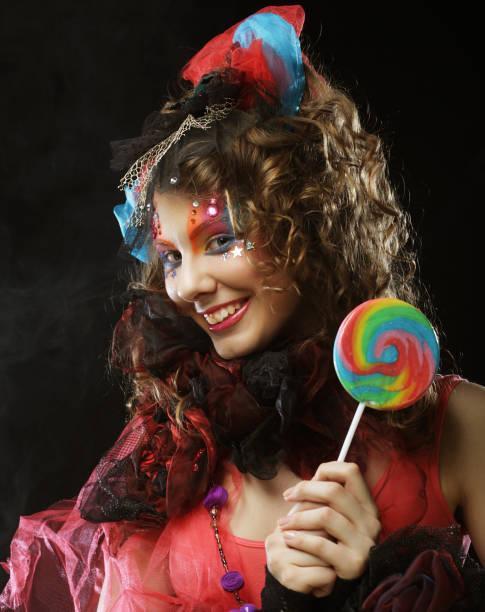 istock Girl with with creative make-up holds lollipop. Doll style 1348235395