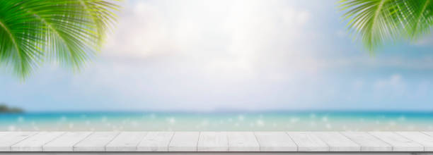 istock The wood table top on blue sea & sky background 1348238406