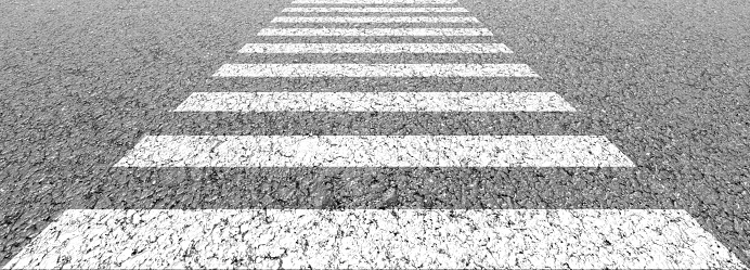 Empty highway black asphalt road and white dividing lines, Crosswalk on the road for safety when people walking across the street, Pedestrian crossing on a repaired asphalt road, Safety First
