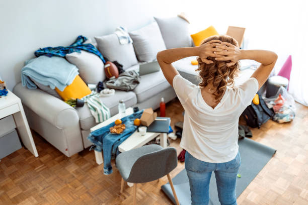 ama de casa en casa moderna en un día soleado mirando la habitación sucia. - caos fotografías e imágenes de stock