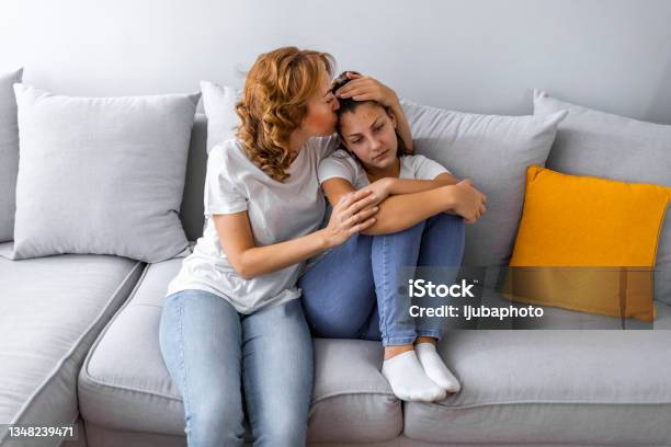 Caring Mother Calming And Hugging Upset Little Daughter Stock Photo - Download Image Now