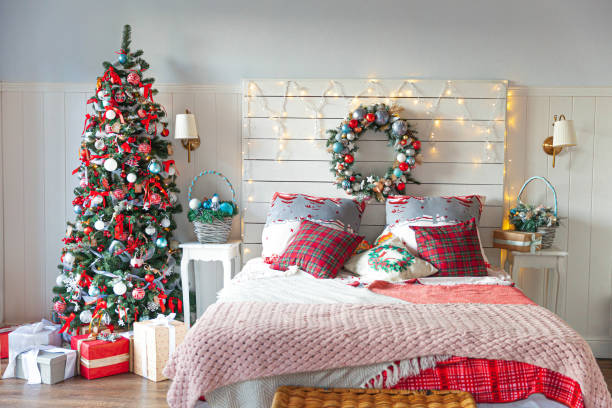 istock Classic interior room with Christmas tree and traditional white red decorations. Modern clean white classical style interior design apartment bedroom. Christmas eve at home. Minimalist home design 1348243105