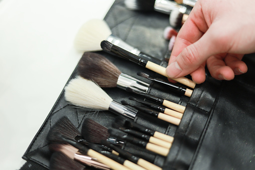 Various different make up brushes on pink background. Selective focus.