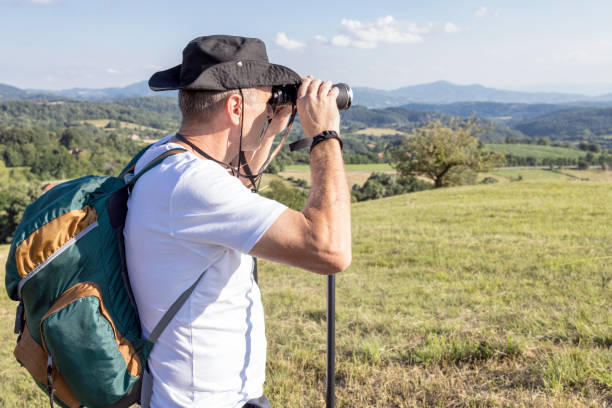 istock Mature hiker using binoculars to observe surroundings 1348246036
