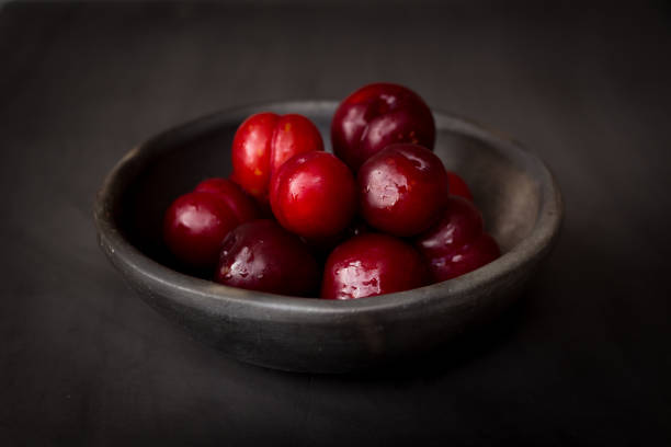 istock plate of fresh plums on dark background 1348246281