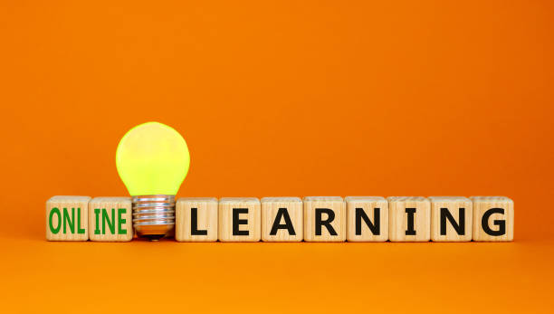 istock Online learning symbol. Wooden cubes with words online learning. Yellow light bulb. Beautiful orange background. Business, education and online learning concept. Copy space. 1348247145