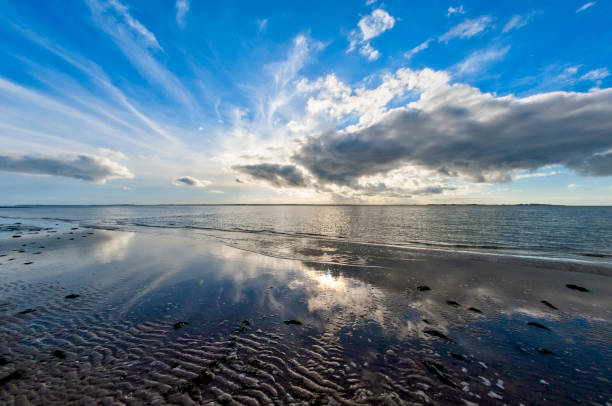 Clouds Clouds and their reflection in the Wadden Sea at low tide on the North Sea island of Föhr german north sea region stock pictures, royalty-free photos & images