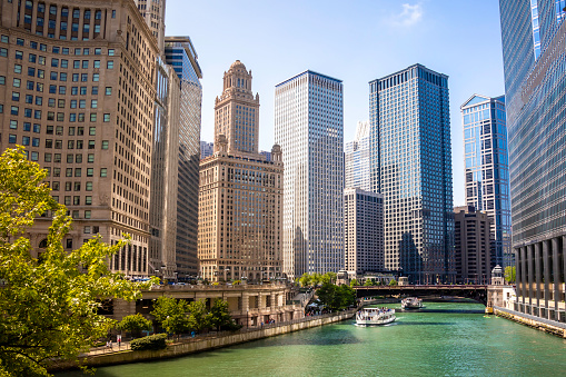 Scenic view of turquoise Chicago River framed by tall skyscrapers on a sunny day