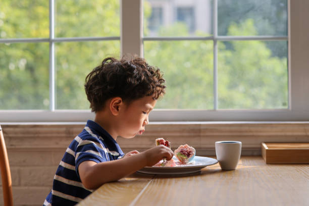 istock A little boy who eats dessert in a restaurant 1348248915