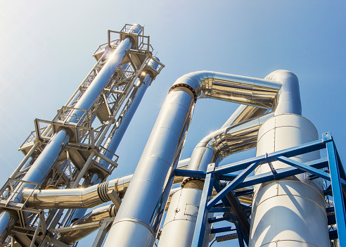 Industrial zone, The equipment of oil refining, Close-up of industrial pipelines of an oil-refinery plant. Process area of Petroleum plant with blue sky.