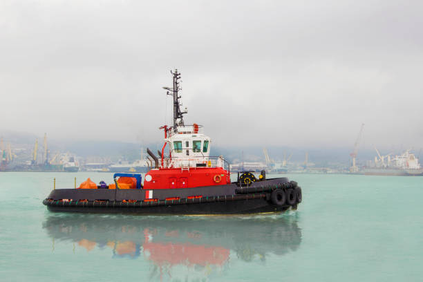 Tugboat on maneuvers at sea. Offshore supply boat in a calm weather day. Logistic import export and transport industry background.