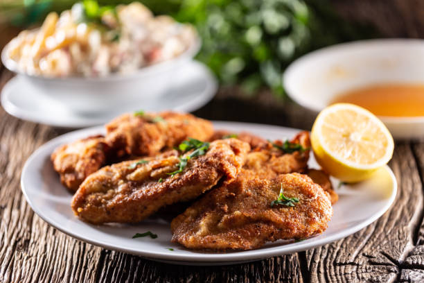 fried steaks and potato salad, a traditional dish served for the christmas or easter holidays. - viennese schnitzel imagens e fotografias de stock