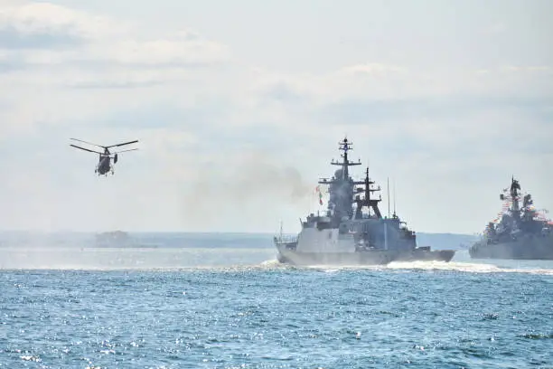 Photo of Battleships war ships corvette during naval exercises and helicopter maneuvering over sea, warships
