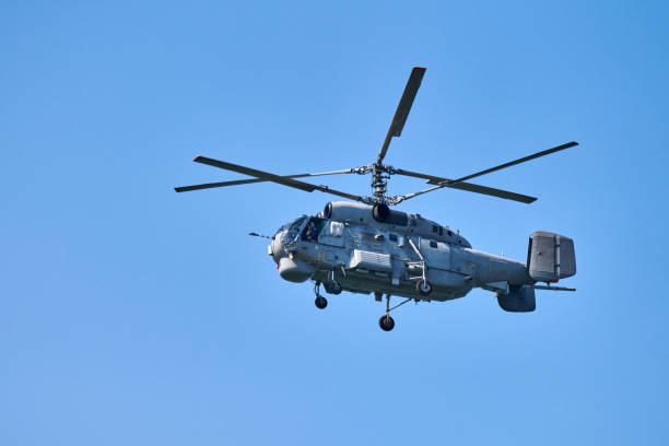 istock Navy helicopter flying against blue sky background, copy space. One rotary wing aircraft, side view 1348250439