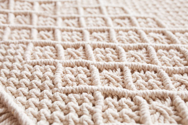 istock Handmade macrame. Macrame braiding and cotton threads.  Female hobby.  ECO friendly modern knitting DIY natural decoration concept in the interior.  100% cotton wall decoration. 1348252273