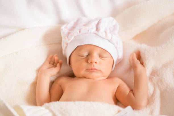 istock newborn in the hat sleeps with arms outstretched. 1348256380