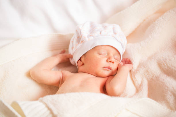 istock newborn in the hat sleeps with arms outstretched. 1348256432