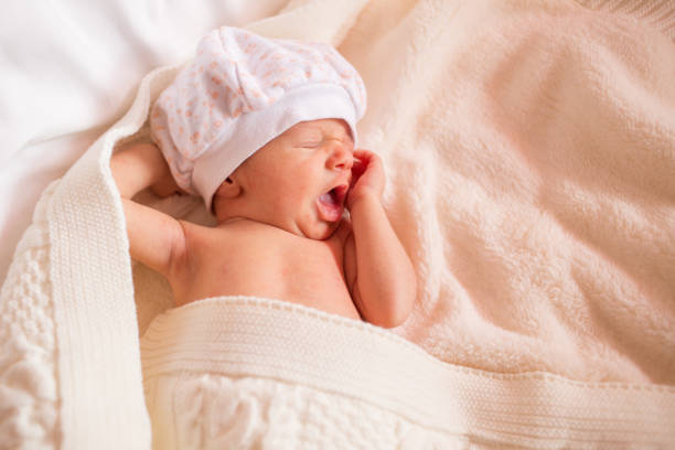 istock newborn boy yawns. small child is sleeping on bed. 1348257623