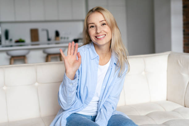 istock Happy woman looking at web camera, waving hand 1348266269