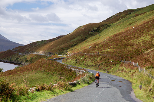 Aasleagh Falls, County Mayo, Ireland: Aug 29, 2020: Cyclist on the road R335, near Tawnyinlough, Leenaun and Aasleagh Falls